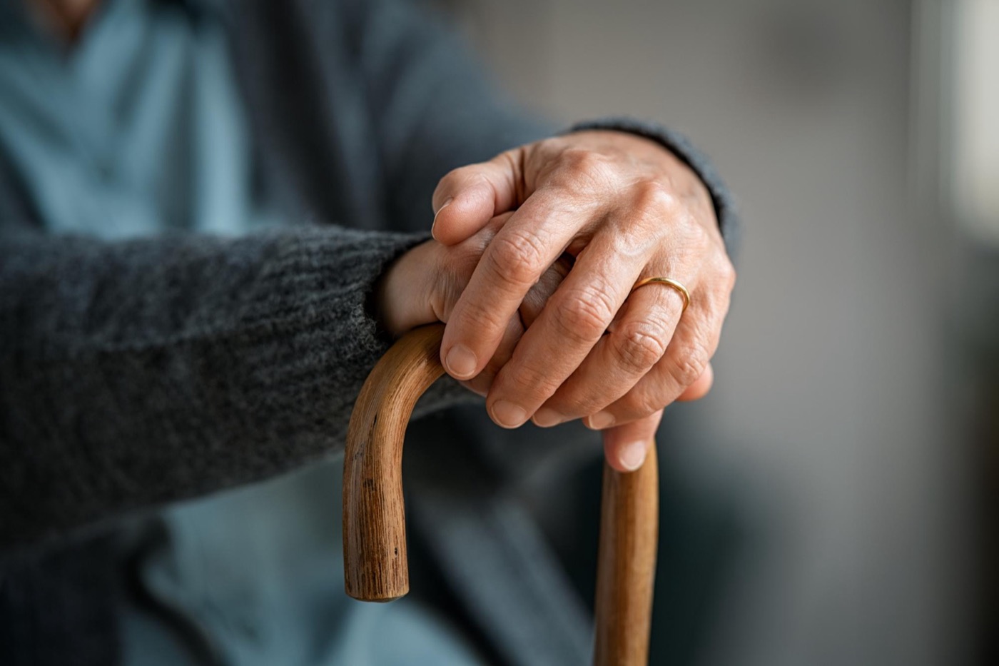 Hände einer älteren Person auf einem Gehstock